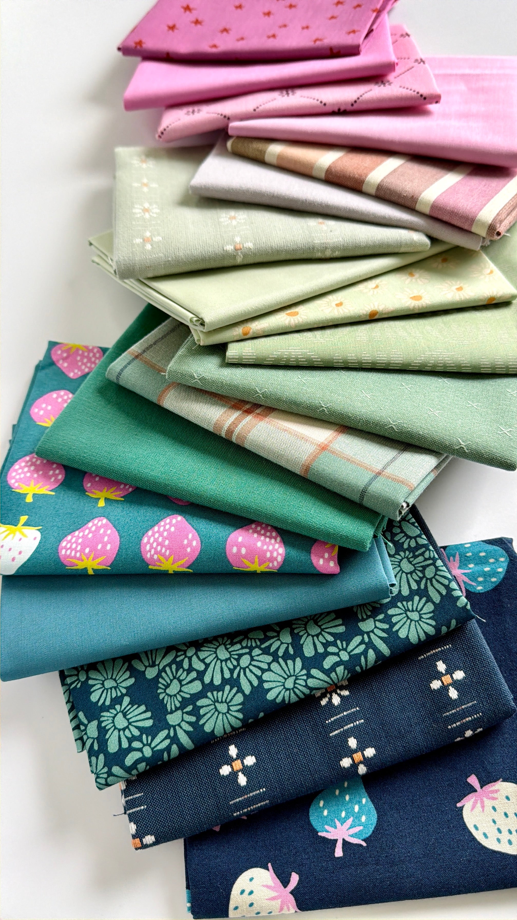 Stack of colorful fabric swatches with various patterns on a white background