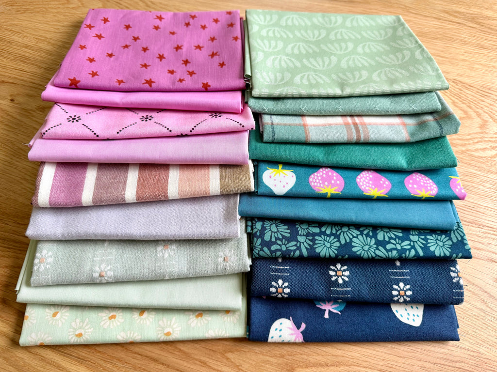 Stack of colorful folded fabrics with various patterns on a wooden surface