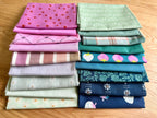 Stack of colorful folded fabrics with various patterns on a wooden surface