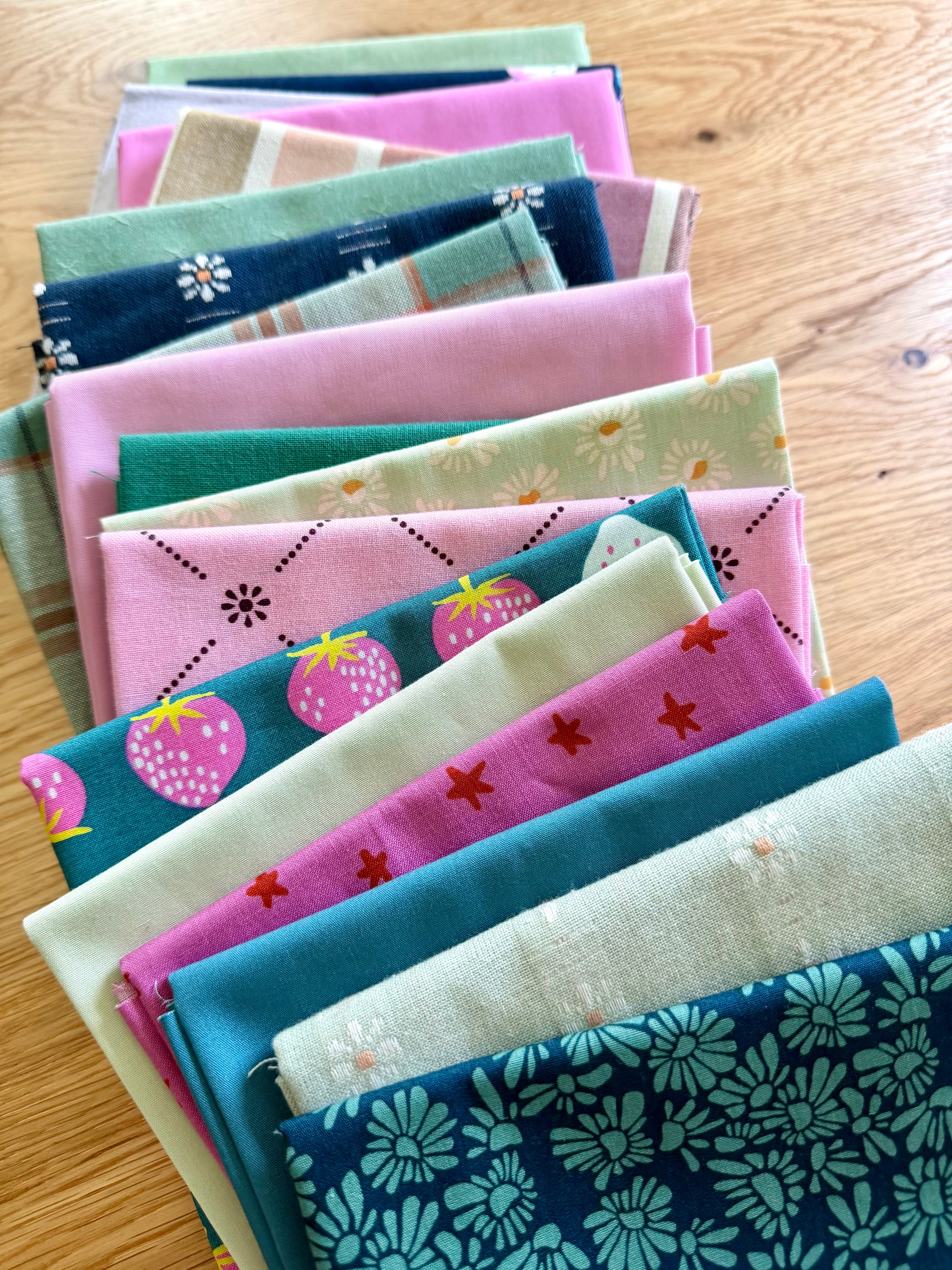 Stack of colorful fabric swatches on a wooden surface