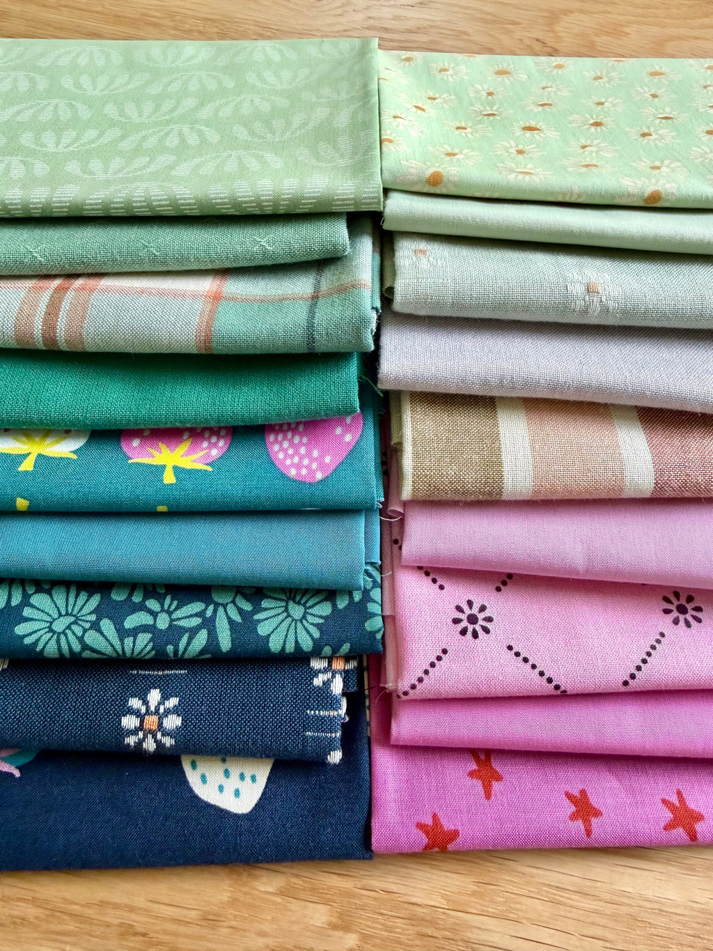 Stack of colorful fabric rolls on a wooden surface