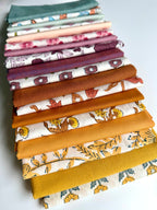 Stack of colorful fabric swatches on a white background