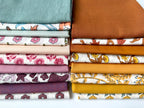 Stack of colorful fabric swatches with various patterns on a white background