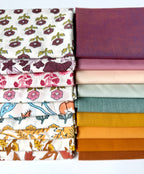 Stack of patterned fabric swatches on a white background
