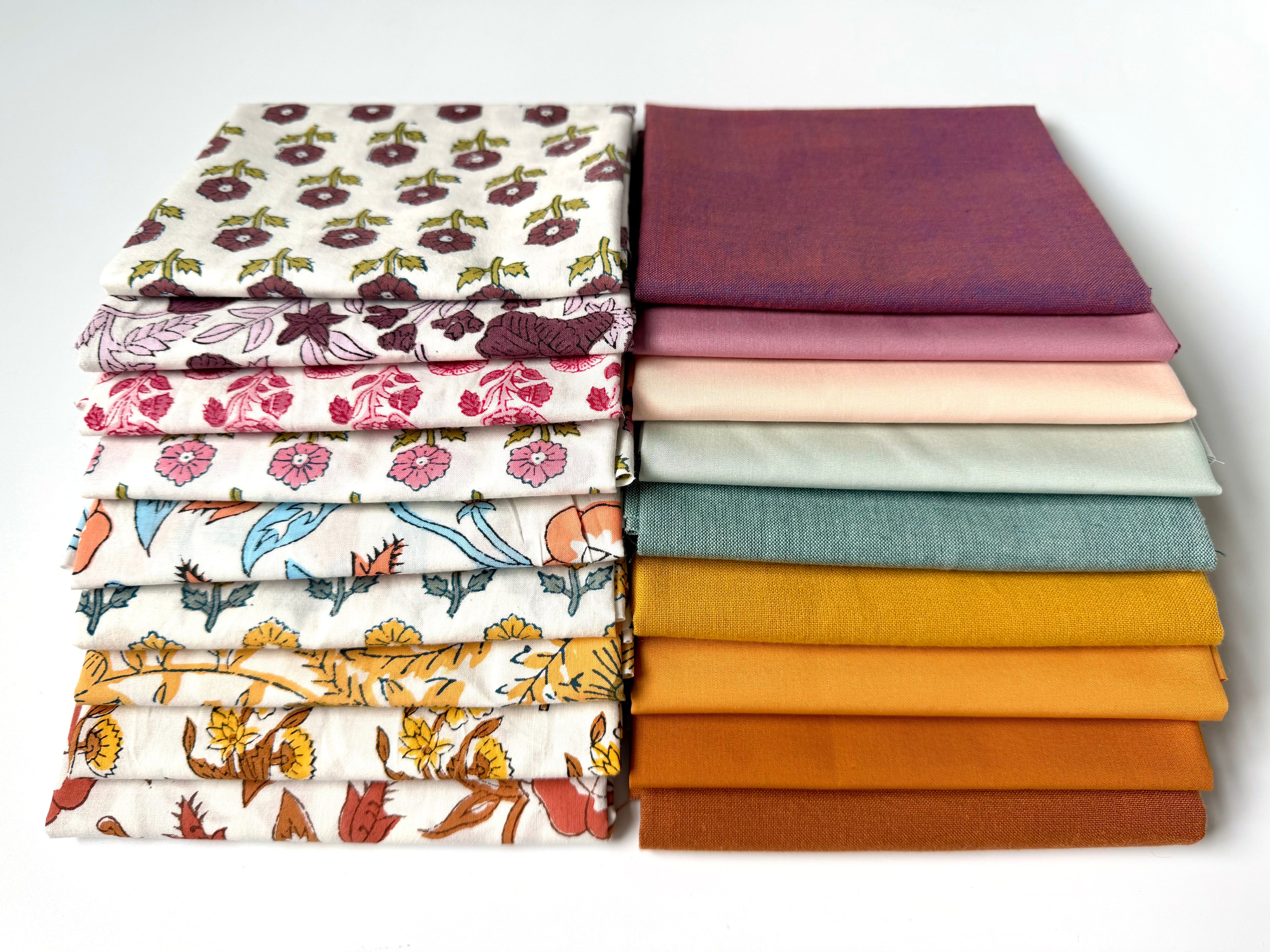 Stack of colorful fabric swatches on a white background