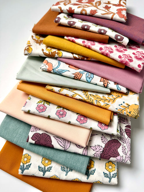 Stack of colorful fabric swatches with floral patterns on a white background