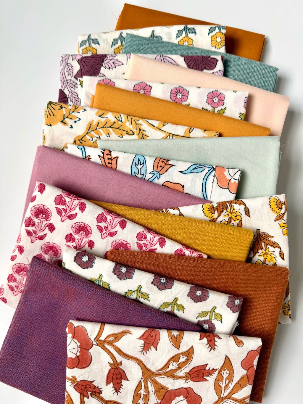 Collection of fabric swatches with various patterns and colors on a white background