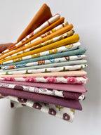 Stack of colorful fabric swatches held by a hand on a light background
