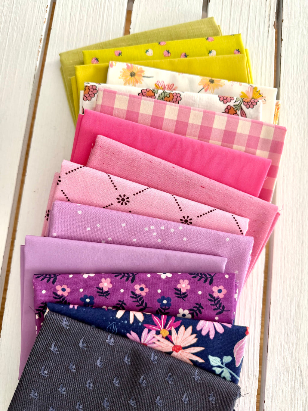 Collection of colorful fabric swatches arranged on a wooden surface