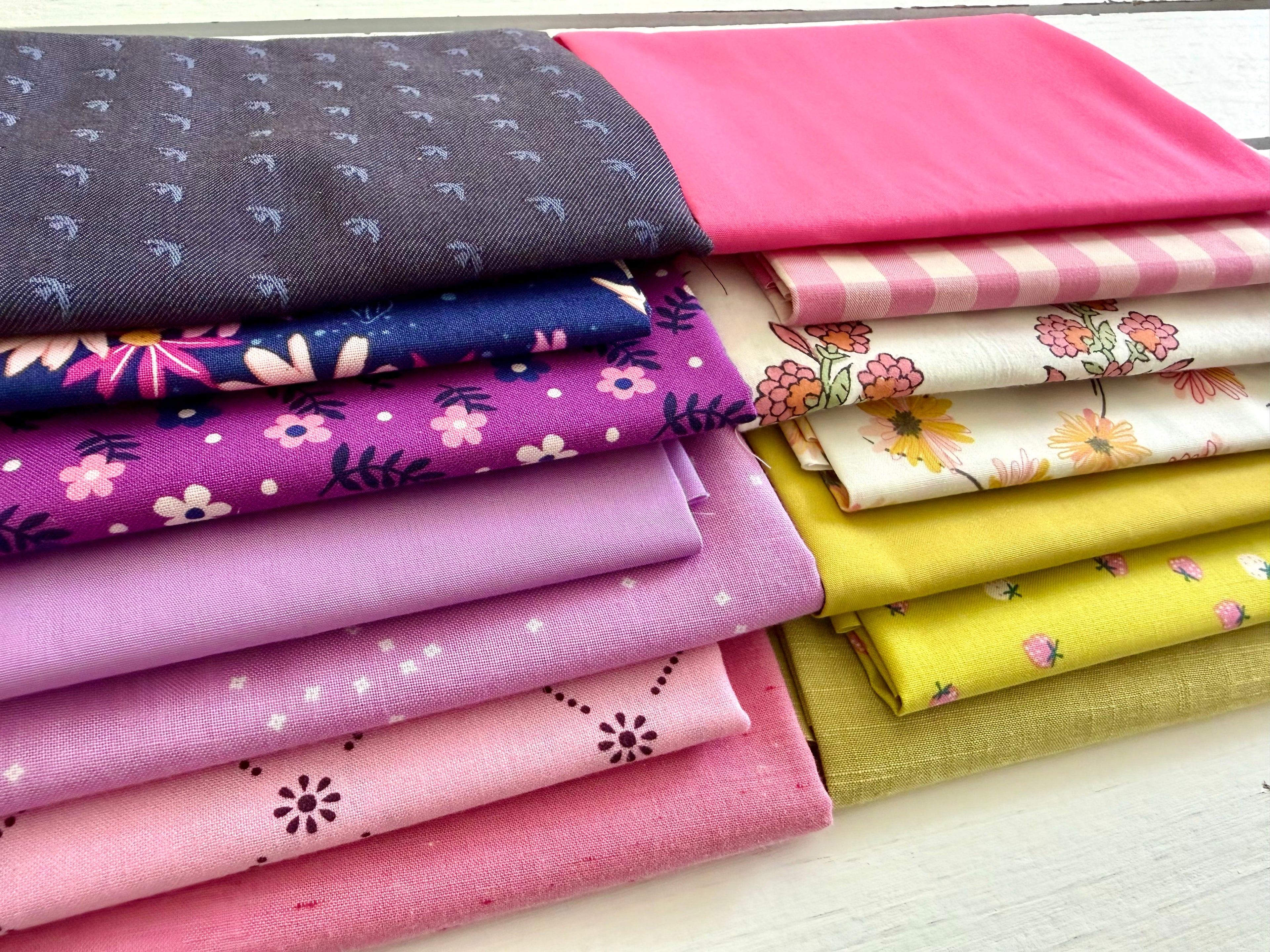 Stack of colorful fabric swatches with various patterns on a white surface