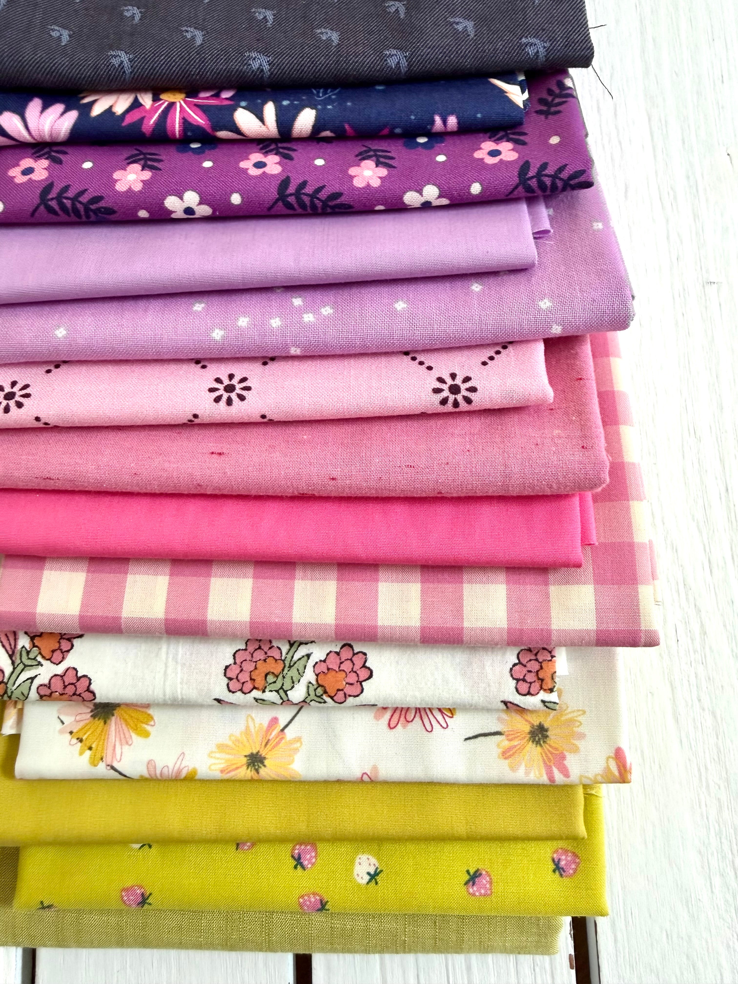 Stack of colorful fabric swatches with various patterns on a white background