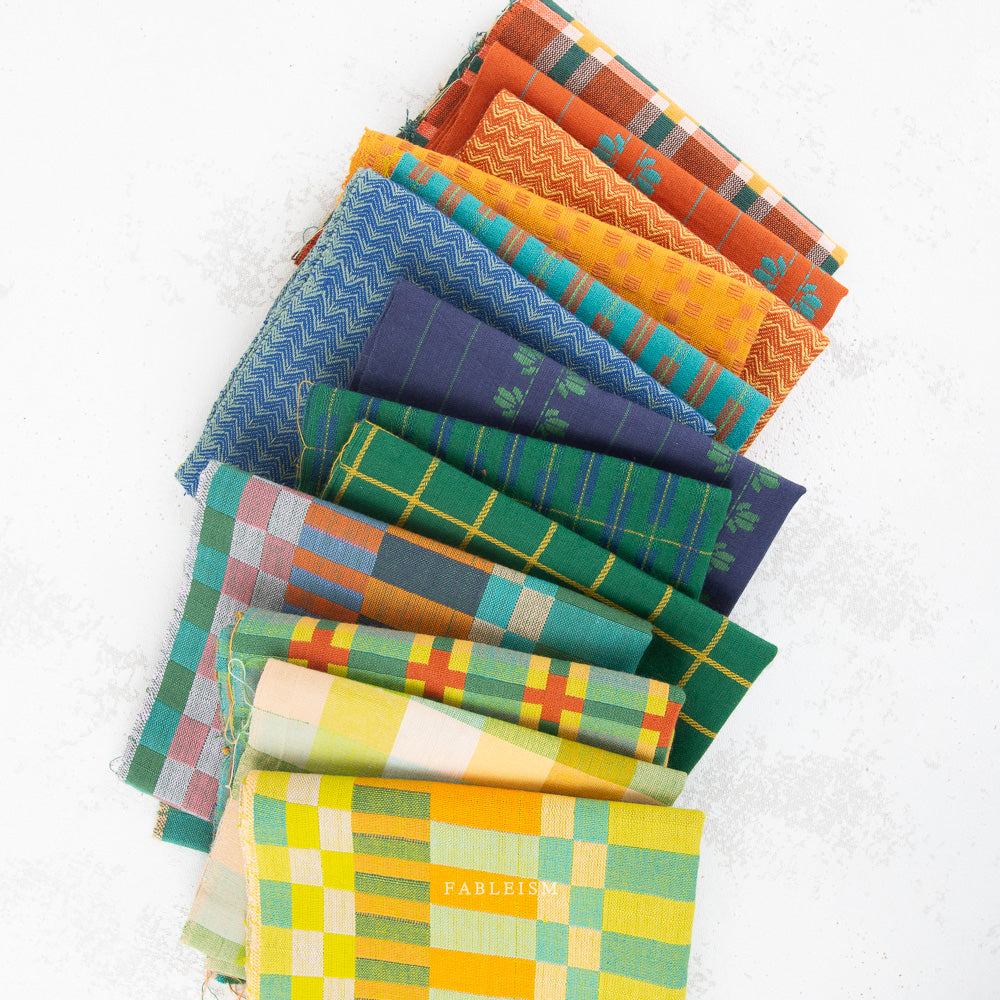 A fan arrangement of colorful patterned fabric squares on a white background, including plaid, check, and chevron designs in orange, blue, green, yellow, and red.