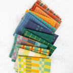 A fan arrangement of colorful patterned fabric squares on a white background, including plaid, check, and chevron designs in orange, blue, green, yellow, and red.